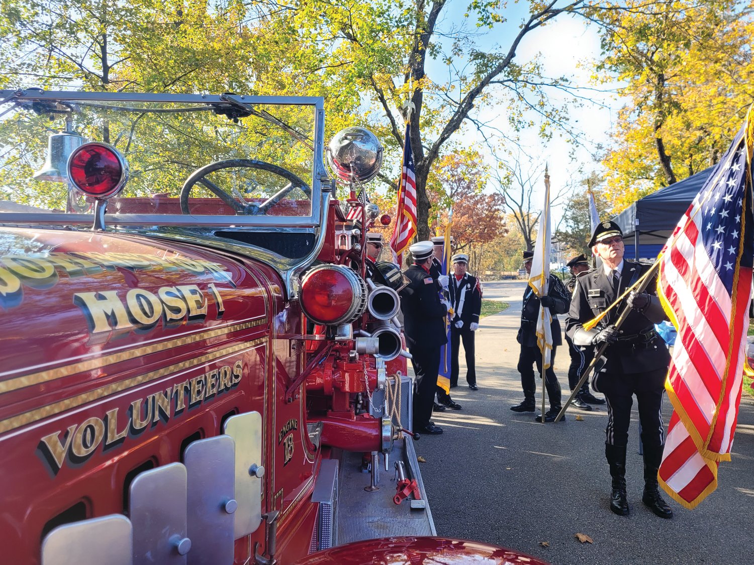RESTORED MAXIM: The morning’s Honor Guards prepped their flags next to the old Hose No. 1 Maxim fire truck.